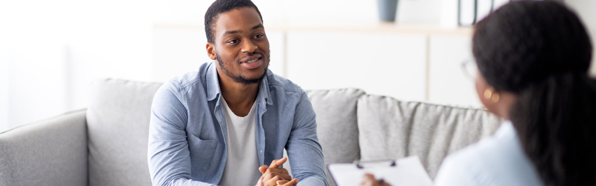 Effective psychotherapy. Young black guy talking to psychologist, receiving professional help at mental health clinic